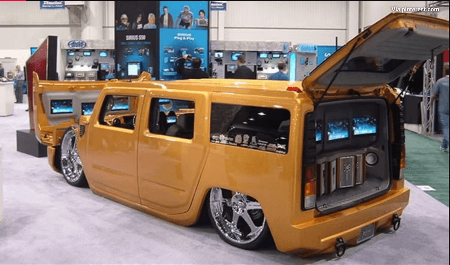 A costum built gold van with large speakers in the trunk