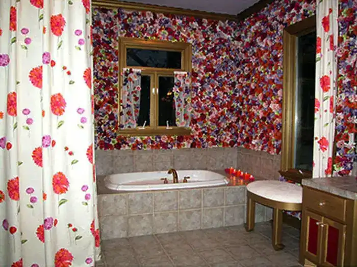 A bathroom with flower painted walls and a bathtub in the middle