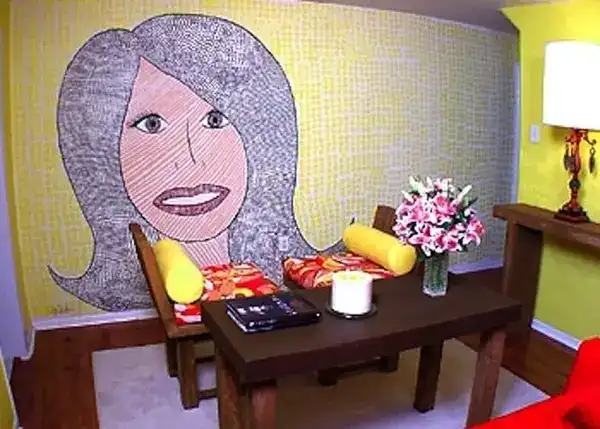 A small room with brown furnituring and a tiled wall picturing a woman.